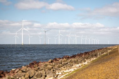 Okyanus açıklarındaki yel değirmeni çiftliği Westermeerwind Parkı 'ndaki yel değirmenleri Hollanda Flevoland Noordoostpolder' ın güneşli bir gününde denizde izole edilmiş.