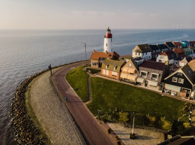 Hollanda Urk Flevoland, Hollanda 'da deniz feneriyle aydınlık bir yaz günü Ijsselmeer Gölü' nün yanındaki tarihi Urk köyünde.