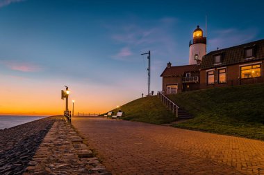 Hollanda Urk Flevoland, Hollanda 'da deniz feneriyle aydınlık bir yaz günü Ijsselmeer Gölü' nün yanındaki tarihi Urk köyünde.