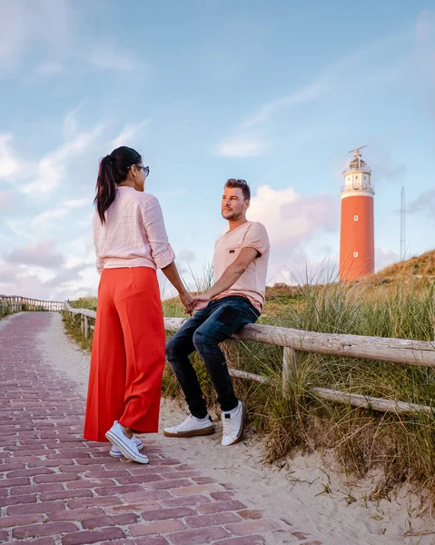 日没時のテセル灯台オランダ島テセル、カップルは休暇中の灯台、男性と女性を訪問｜テセル — ストック写真
