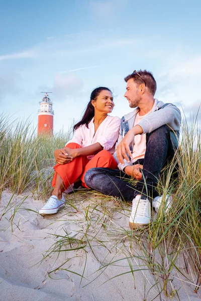 Texel maják při západu slunce Nizozemsko Holandský ostrov Texel, pár navštívit maják, muži a žena na dovolené Texel — Stock fotografie