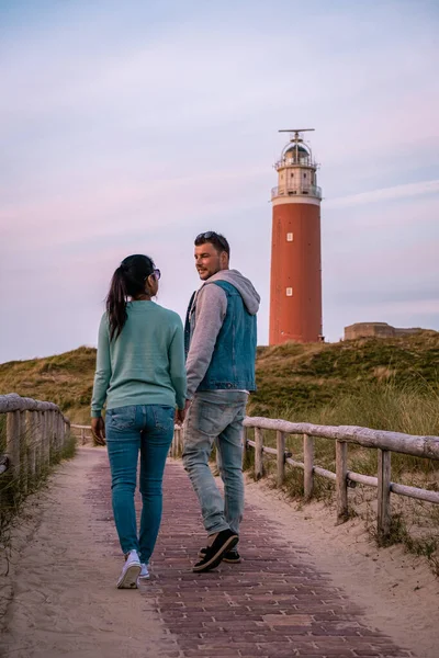 日没時のテセル灯台オランダ島テセル、カップルは休暇中の灯台、男性と女性を訪問｜テセル — ストック写真