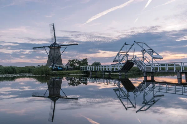 Windmill village Kinderdijk Netherlands, Sunset at the lake by the Dutch wind mill village with wooden windmills Kinderdijk Holland — Stock Photo, Image