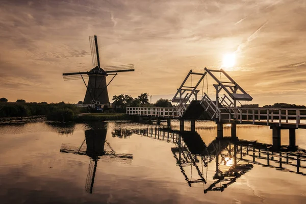 Molino de viento pueblo Kinderdijk Países Bajos, Puesta de sol en el lago por el pueblo molino de viento holandés con molinos de viento de madera Kinderdijk Holanda —  Fotos de Stock