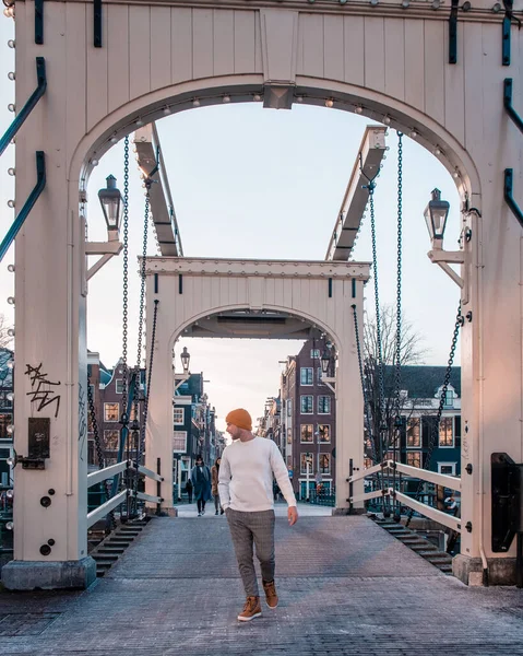 Młodzieniec na wycieczce po Amsterdamie Holandia, mężczyźni zwiedzający kanały Amsterdamu ze starym kanałem i mostem — Zdjęcie stockowe