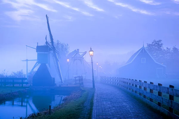 Zaanse Schans Netherlands - нідерландське село вітряків під час заходу сонця з дерев'яним дахом. — стокове фото
