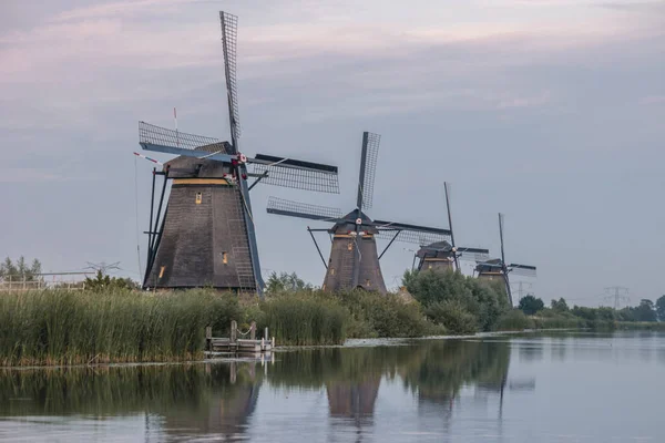 Windmill village Kinderdijk Netherlands, Sunset at the lake by the Dutch wind mill village with wooden windmills Kinderdijk Holland — Stock Photo, Image