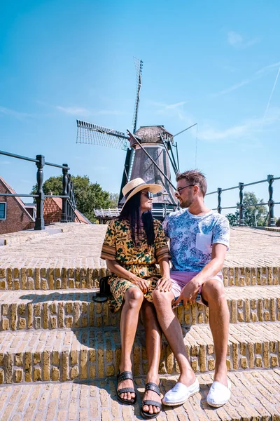 Pareja joven de vacaciones Frisia Países Bajos Sloten, casco antiguo de Sloten Países Bajos con canales y molino de viento — Foto de Stock