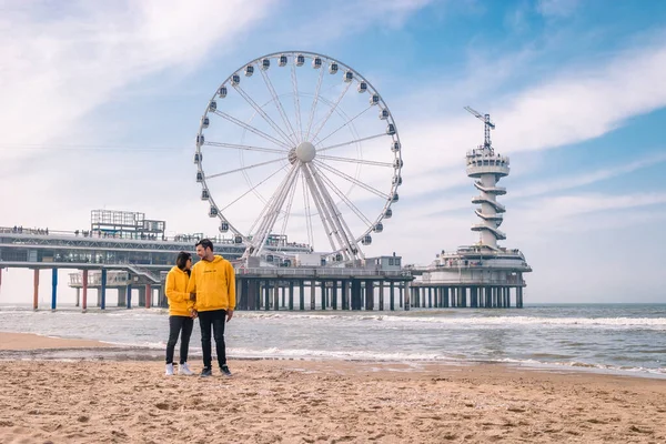 春のオランダ・シュエニンゲンのビーチでのカップル、フェリスホイールオランダのシュエニンゲンの桟橋、ビーチでの春の日 — ストック写真
