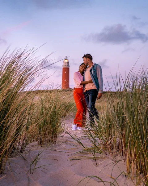 Texel maják při západu slunce Nizozemsko Holandský ostrov Texel, pár navštívit maják, muži a žena na dovolené Texel — Stock fotografie