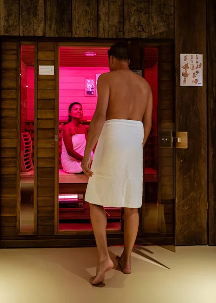 couple in sauna, men and woman in bathrobe visiting a hot sauna