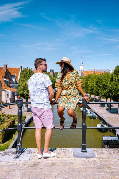 Pareja joven de vacaciones Frisia Países Bajos Sloten, casco antiguo de Sloten Países Bajos con canales y molino de viento — Foto de Stock