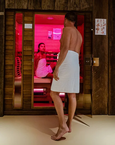 couple in sauna, men and woman in bathrobe visiting a hot sauna