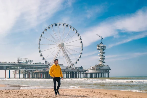 Homens na praia de Schevening Holanda durante a primavera, The Ferris Wheel The Pier em Scheveningen, Holanda, dia de primavera ensolarado na praia — Fotografia de Stock