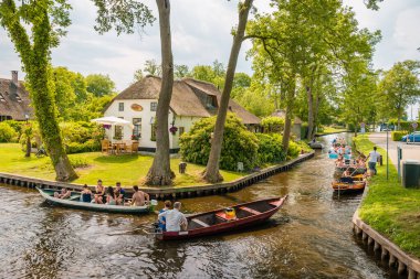 Giethoorn Hollanda Mayıs 2018, Kanalları ve kırsal sazlı çatı evleri ile ünlü köy manzaralı sıcak bir bahar günü