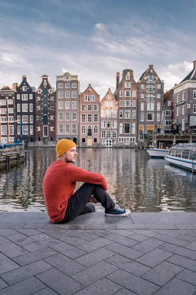 Amsterdam Damrak during sunset, happy man on a autumn evening at the canals — Stock Photo, Image