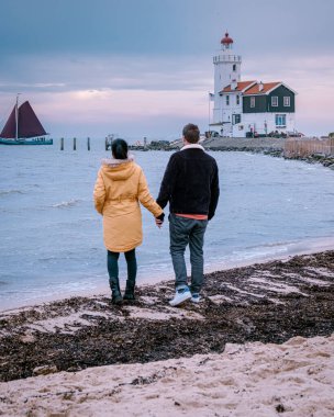 Hollanda 'daki Paard van Marken Deniz Feneri, Marken Holland balıkçı köyünü ziyaret eden bir çift.