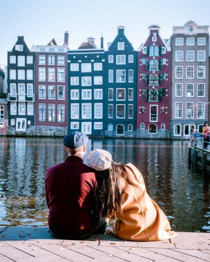 Amsterdam Damrak gün batımında, mutlu çift bir yaz akşamı kanallarda