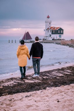 Hollanda 'daki Paard van Marken Deniz Feneri, Marken Holland balıkçı köyünü ziyaret eden bir çift.