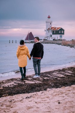 Hollanda 'daki Paard van Marken Deniz Feneri, Marken Holland balıkçı köyünü ziyaret eden bir çift.
