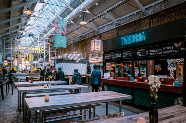 AMSTERDAM, NETHERLANDS - Kasım 2019: Amsterdam 'ın göbeğindeki popüler yemek salonu Foodhallen. Turist bölgesindeki ünlü fast food mutfağı. Egzotik yemekleri tat. 