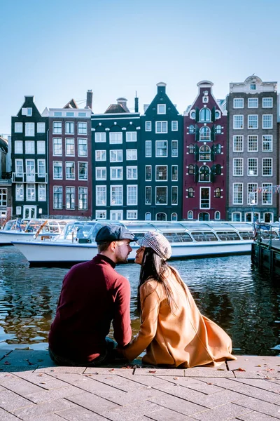 Amsterdam Damrak durante el atardecer, pareja feliz hombre y mujer en una noche de verano en los canales — Foto de Stock