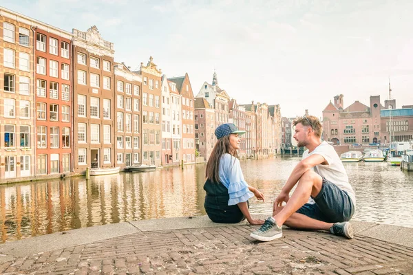 Amsterdam Damrak during sunset, happy couple man and woman on a summer evening at the canals — Stock Photo, Image