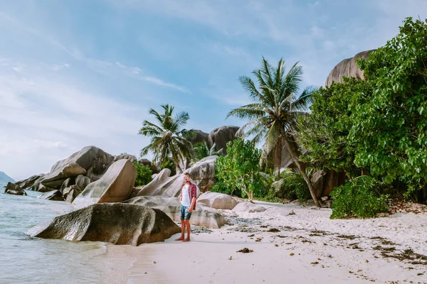 La Digue Seychellen, junge Männer spazieren am weißen Strand mit klarem blauen Meer im Urlaub auf der tropischen Insel — Stockfoto