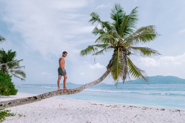 La Digue Seychelles, young men walking at the white beach with clear blue ocean on vacation at the tropical Island — Stock Photo, Image