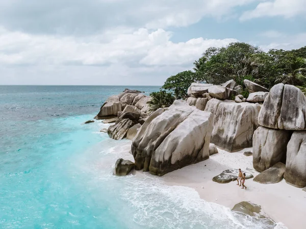 Seychelles, pareja de hombres y mujeres en la playa durante sus vacaciones en las Seychelles visitan la isla tropical del Coco — Foto de Stock