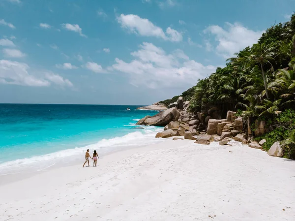 Seychelles, pareja de hombres y mujeres en la playa durante sus vacaciones en las Seychelles visitan la isla tropical del Coco — Foto de Stock