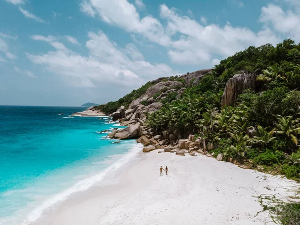 Σεϋχέλλες, δύο άνδρες και γυναίκες στην παραλία κατά τη διάρκεια των διακοπών στις Σεϋχέλλες επισκεφθείτε το τροπικό νησί Coco — Φωτογραφία Αρχείου