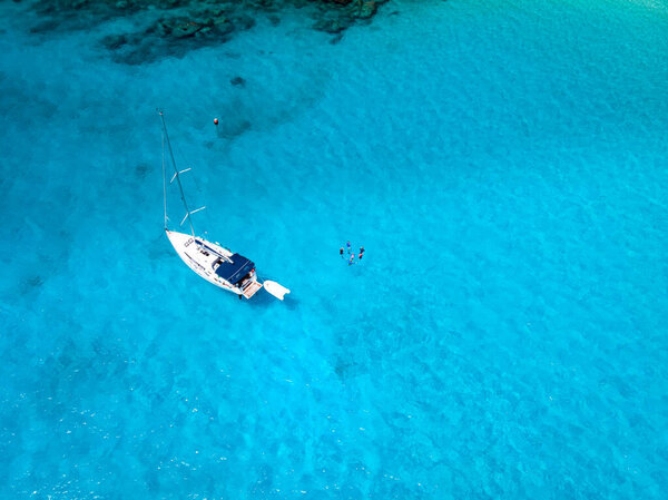 white sailing boat in the blue ocean near Pralsin Seychelles