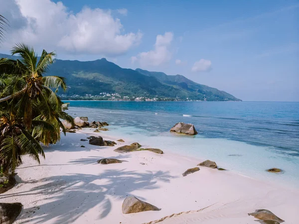 Tropischer weißer Strand auf der Insel Praslin Seychellen, glückliches junges Paar im Urlaub Urlaub Urlaub am Strand unter einer Palme — Stockfoto
