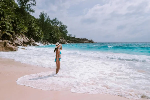 Petite Anse Mahe Seychelles, young woman on the beach, mid age Asian woman walking on tropical beach Seychelles