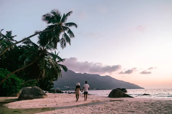 Playa blanca tropical en la isla de Praslin Seychelles, feliz Pareja joven hombre y mujer durante las vacaciones Vacaciones en la playa relajándose bajo una palmera —  Fotos de Stock