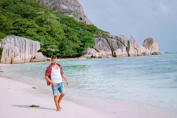 라 디 그 세이 셸 (La Digue Seychelles), 열 대 섬라 디 그 (La Digue) 에서 휴가를 보내고 있는 젊은 남성들, 열 대 해변 세이 셸 (Seychelles) 에서 휴가를 즐기고 있는 중년 남자들 — 스톡 사진