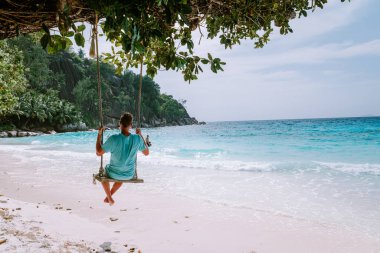 La Digue Seyşeller, tropik ada La Digue 'da tatilde olan genç erkekler, tropik sahil Seyşelleri' nde tatilde sahilde yürüyen orta yaşlı bir adam.
