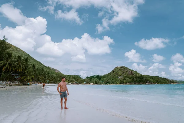 Cote dOr Beach Praslin Seychelles, young mid age men in swim short walking on the beach during vacation Secyhelles tropical Island, white guy on beach during holiday Praslin — Stock Photo, Image