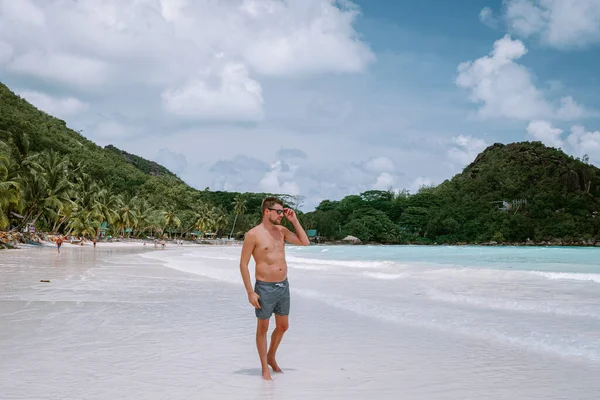 Cote dOr Beach Praslin Seyşeller, tatilde sahilde kısa süre yüzen orta yaşlı adamlar Secyhelles tropikal adasında yürüyen, Praslin tatilinde sahilde olan beyaz adam. — Stok fotoğraf