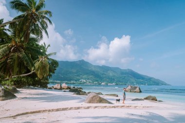La Digue Seyşeller, tropik ada La Digue 'da tatilde olan genç erkekler, tropik sahil Seyşelleri' nde tatilde sahilde yürüyen orta yaşlı bir adam.