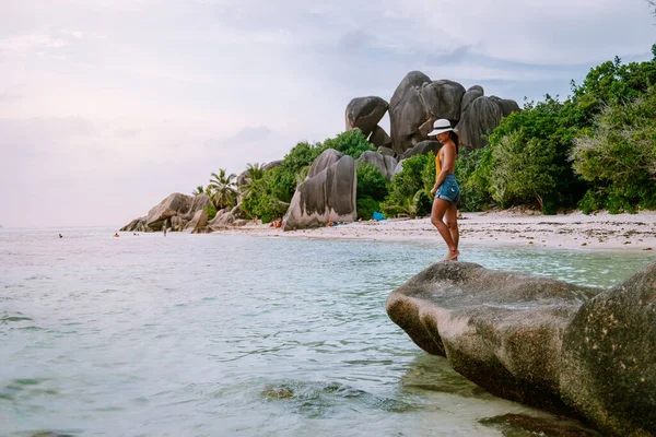 La Digue Seychelles, puesta de sol en la playa tropical blanca con palmera, mujer joven de vacaciones en las Seychelles, chica de destino de vacaciones de lujo en la playa blanca — Foto de Stock