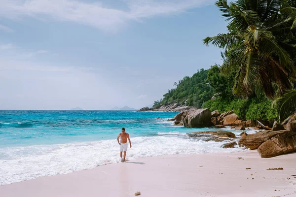 La Digue Seychelles, pria muda berlibur di pulau tropis La Digue, pria paruh baya berjalan di pantai selama liburan di pantai tropis Seychelles — Stok Foto