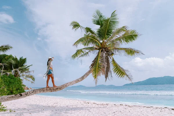 La Digue Seszele, zachód słońca na białej tropikalnej plaży z palmą, młoda kobieta na wakacjach na Seszelach, luksusowa dziewczyna na białej plaży — Zdjęcie stockowe