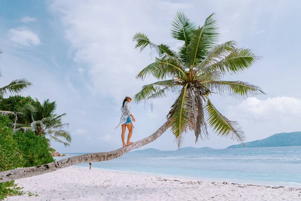 La Digue Seszele, zachód słońca na białej tropikalnej plaży z palmą, młoda kobieta na wakacjach na Seszelach, luksusowa dziewczyna na białej plaży — Zdjęcie stockowe