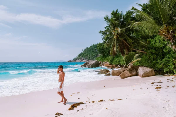 라 디 그 세이 셸 (La Digue Seychelles), 열 대 섬라 디 그 (La Digue) 에서 휴가를 보내고 있는 젊은 남성들, 열 대 해변 세이 셸 (Seychelles) 에서 휴가를 즐기고 있는 중년 남자들 — 스톡 사진