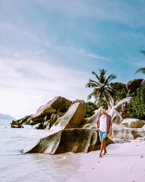 La Digue Seychellerna, unga män på semester på den tropiska ön La Digue, medelålders kille promenader på stranden under semester på tropiska stranden Seychellerna — Stockfoto
