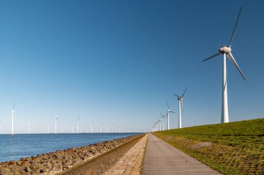 Okyanus açıklarındaki yel değirmeni çiftliği Westermeerwind Parkı 'ndaki yel değirmenleri Hollanda Flevoland Noordoostpolder' ın güneşli bir gününde denizde izole edilmiş.