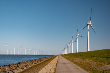 Okyanus açıklarındaki yel değirmeni çiftliği Westermeerwind Parkı 'ndaki yel değirmenleri Hollanda Flevoland Noordoostpolder' ın güneşli bir gününde denizde izole edilmiş.