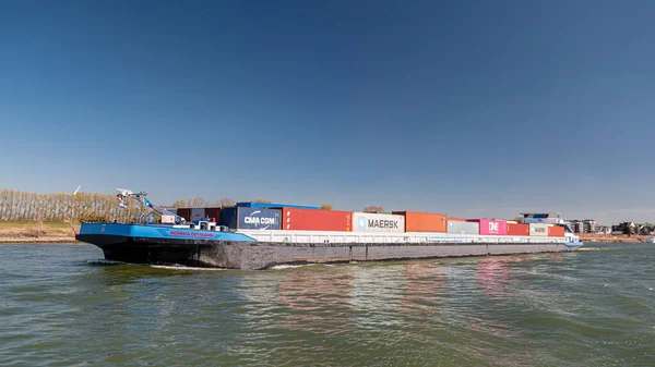 Lobith Holandia, kwiecień 2020, duży kontenerowiec na rzece Rhein w pobliżu Niemiec z kolorowymi kontenerami na pokładzie podczas jasnego dnia wiosną — Zdjęcie stockowe